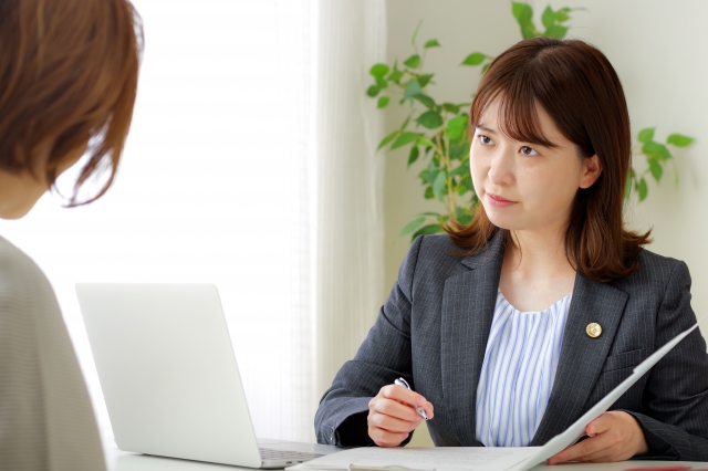 女性弁護士が相談者の話を真剣に聞き、書類を確認している場面